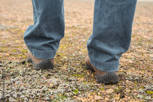 Foto a nivel del suelo de botas de montaña de hombre sobre suelo lleno de musgo