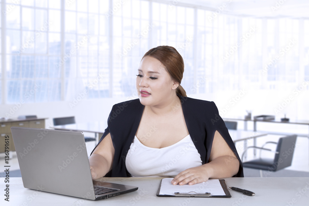 Woman works with laptop and clipboard Woman works with laptop and clipboard