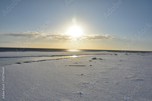 朝日と雪の砂浜