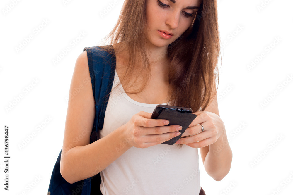 pretty young students girl with blue backpack on shoulder and mobile phone in hands posing isolated on white background pretty young students girl with blue backpack on shoulder and mobile phone in hands posing isolated on white background