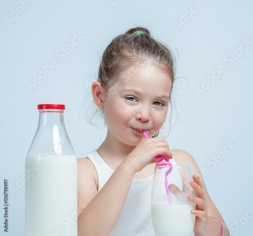 beautiful cute little girl drinking milk with straw photo