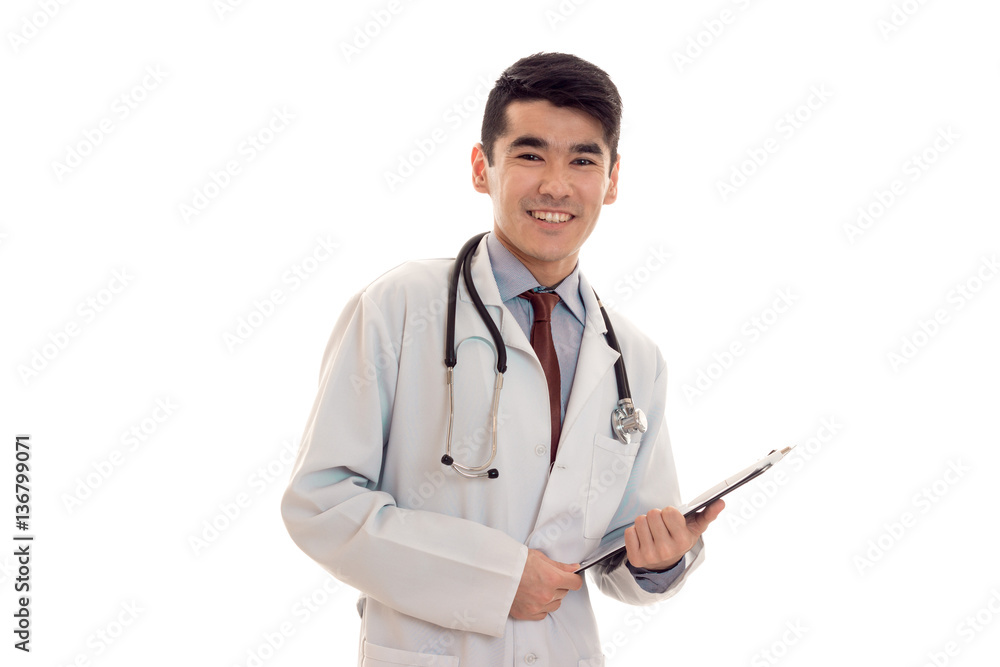 happy male doctor in uniform with stethoscope makes notes isolated on white background happy male doctor in uniform with stethoscope makes notes isolated on white background