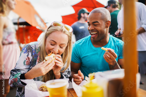 Photo couple having fun time eating burgers and drinking beer