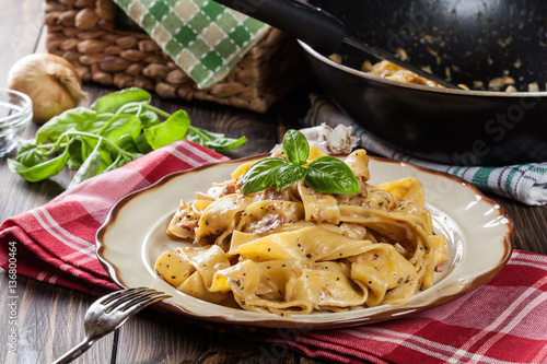 Pappardelle pasta with prosciutto and cheese sauce on a plate