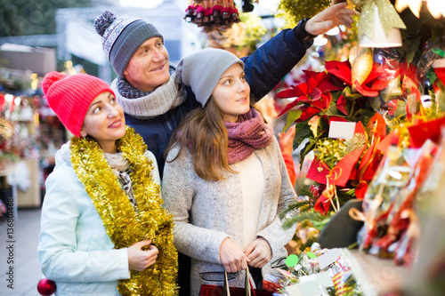 friendly parents with teenage girl at counter with Poinsettia an