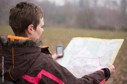 female geocacher hiking with gps photo