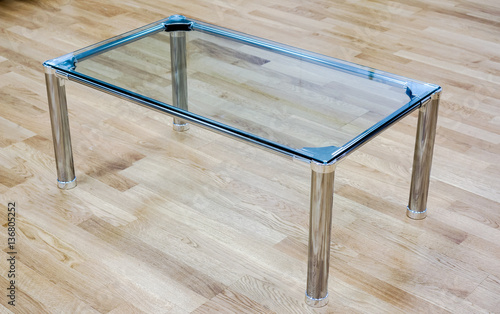 Clear glass small table against wooden floor on office reception