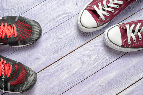 two pair of gumshoes on a wooden background with copy space photo