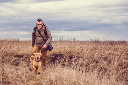 Hiker and dog in grassland