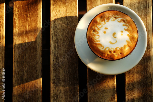 the sun foam design in hot latte coffee and suger on rough wooden table