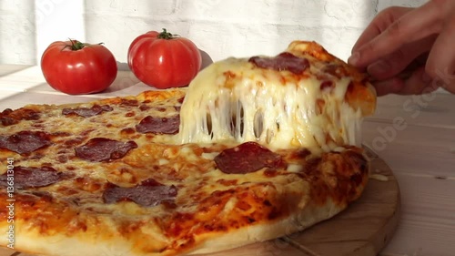 taking slice of pizza with super stretching cheese