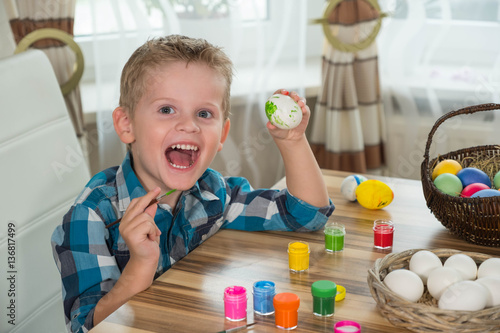 Boy painting easter eggs