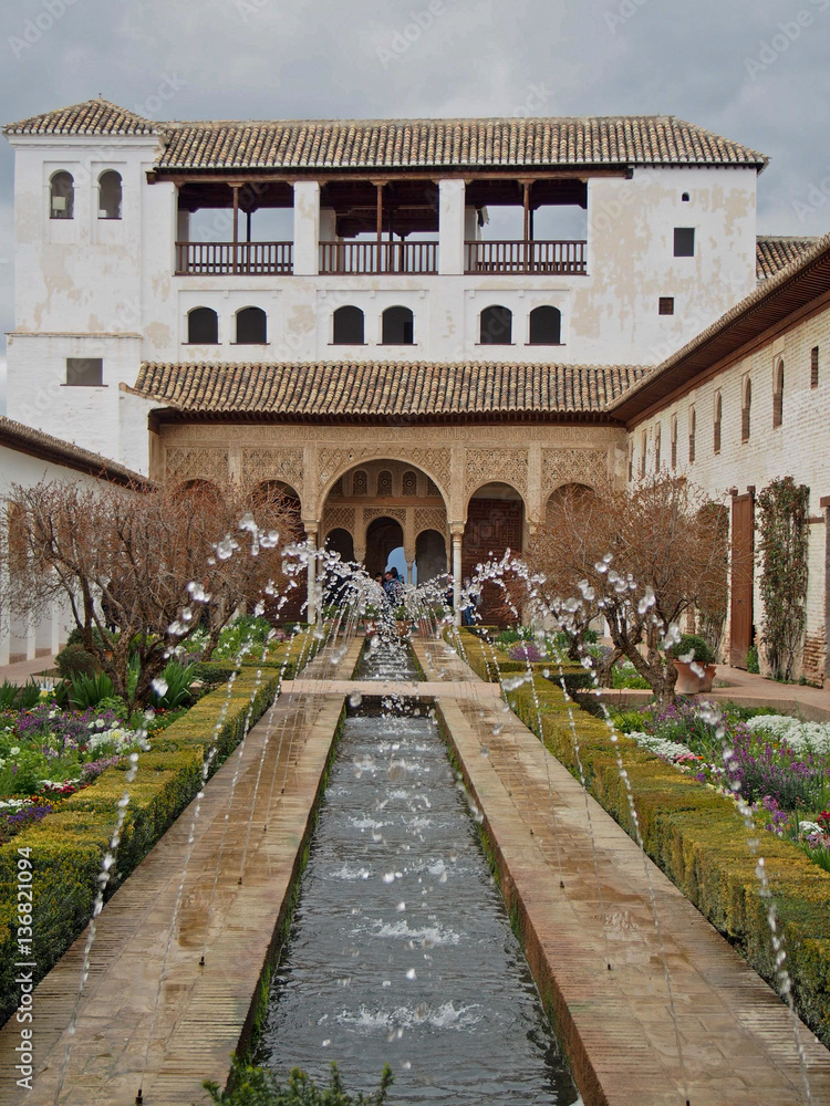 A decorative fountain spraying water inside of Alhambra Fort in Granada, Spain.