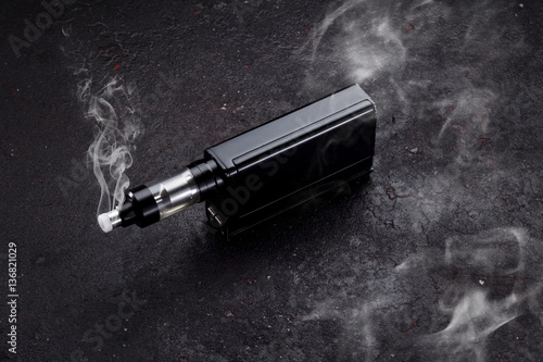 An electonic cigarette over dark concrete background