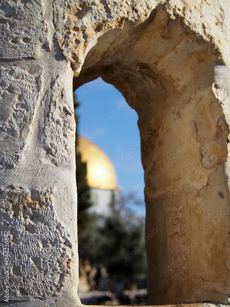 The view through a stone window in historic Jerusalem includes the iconic gold-domed mosque on the Temple Mount.