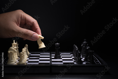 One chess pieces staying against black chess pieces