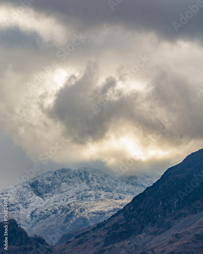 Dramatic moody storm clouds over the Borrowdale Valley in the English Lake District with snowcapped mountains.
