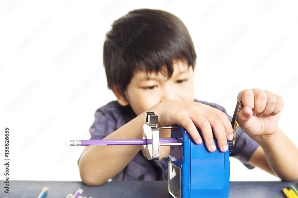 A boy is sharpening his pencil using mechanical sharpener over white background A boy is sharpening his pencil using mechanical sharpener over white background