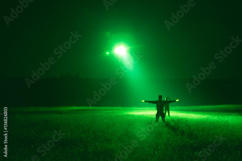 marshaller signal to helicopter for night landing from night vision goggles view
