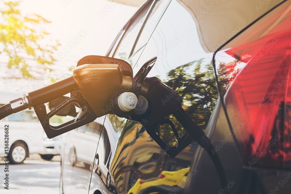 Refueling car tank with gasoline nozzle head Refueling car tank with gasoline nozzle head