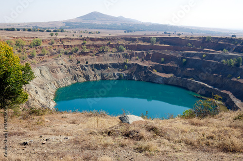 Abandoned open ore mine pit partially full of water