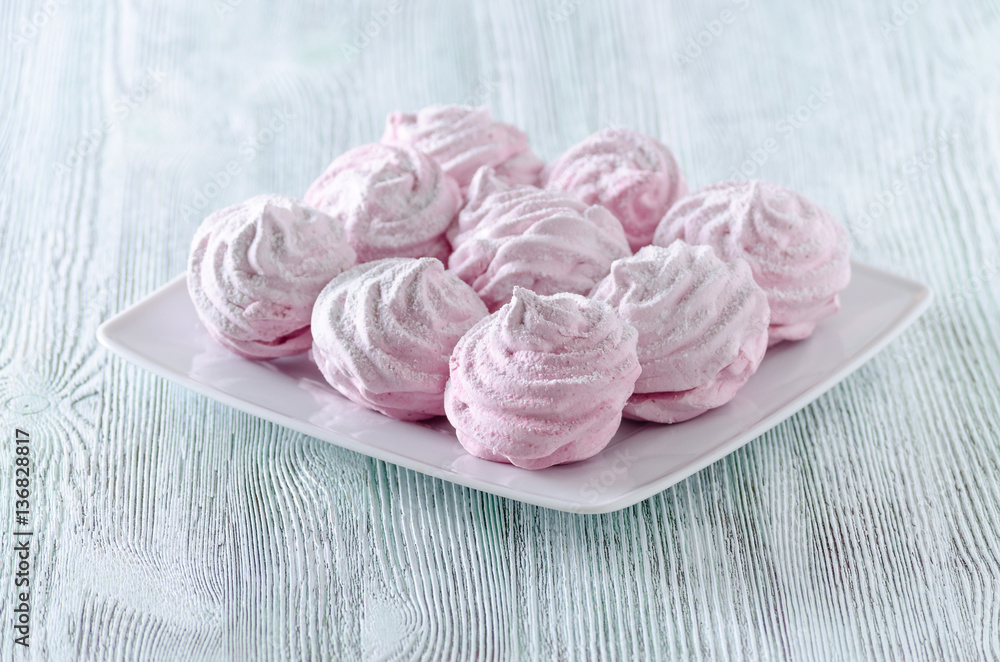 lovely pastel rose meringues, zephyrs, marshmallows on the wooden vintage table