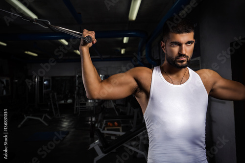 Handsome young man is exercising in the gym