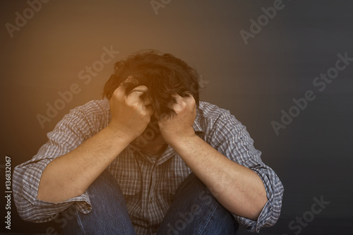 Sad man holding head with hand photo