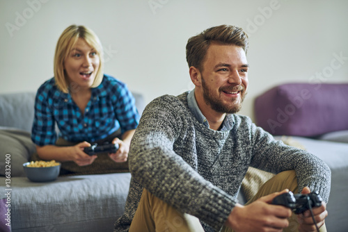 Young cheerful couple at home playing video games
