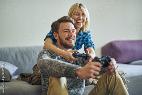 Young cheerful couple at home playing video games