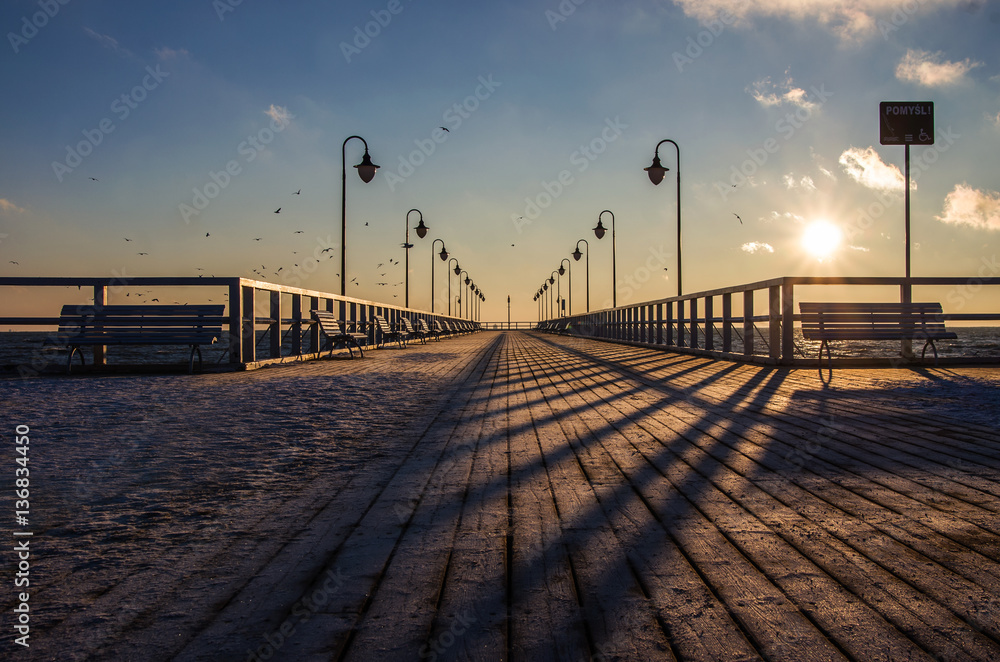 Fototapeta premium Molo w zimowej scenerii, zimowy poranek, wschód słońca. 