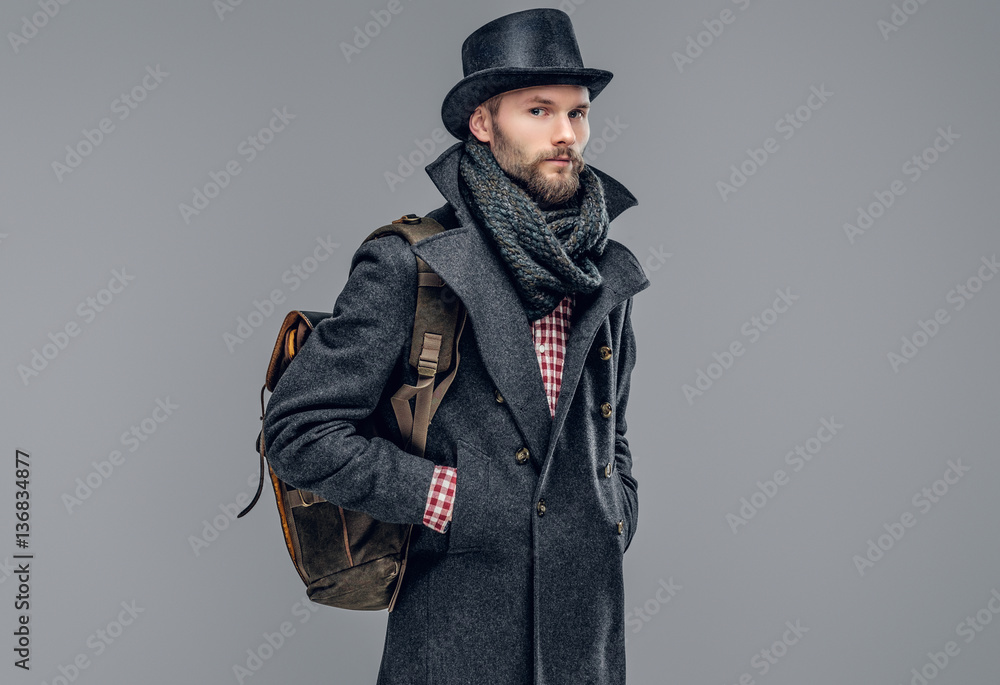 A man in a jacket holds a backpack. A man in a jacket holds a backpack.