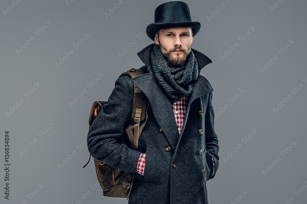 A man in a jacket holds a backpack. A man in a jacket holds a backpack.