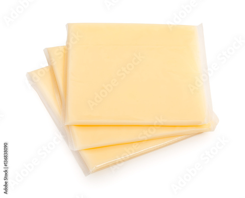 Three yellow cheese slices packaged on white background. Close-u