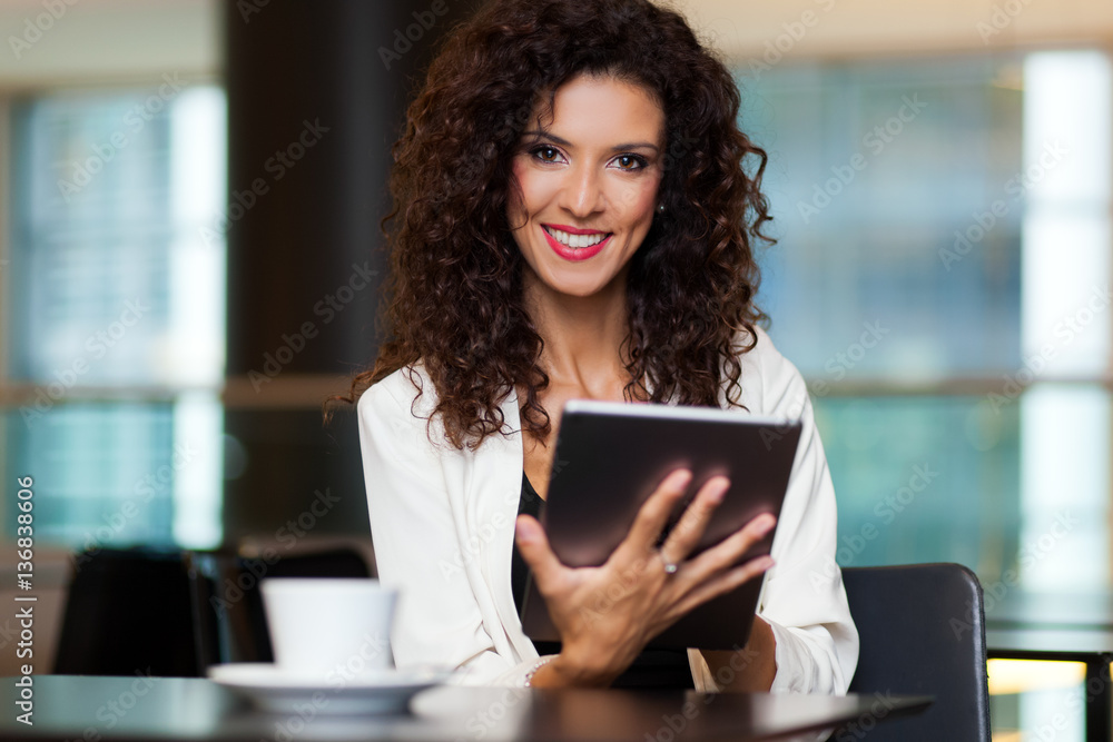 Woman using her tablet in a cafe Woman using her tablet in a cafe