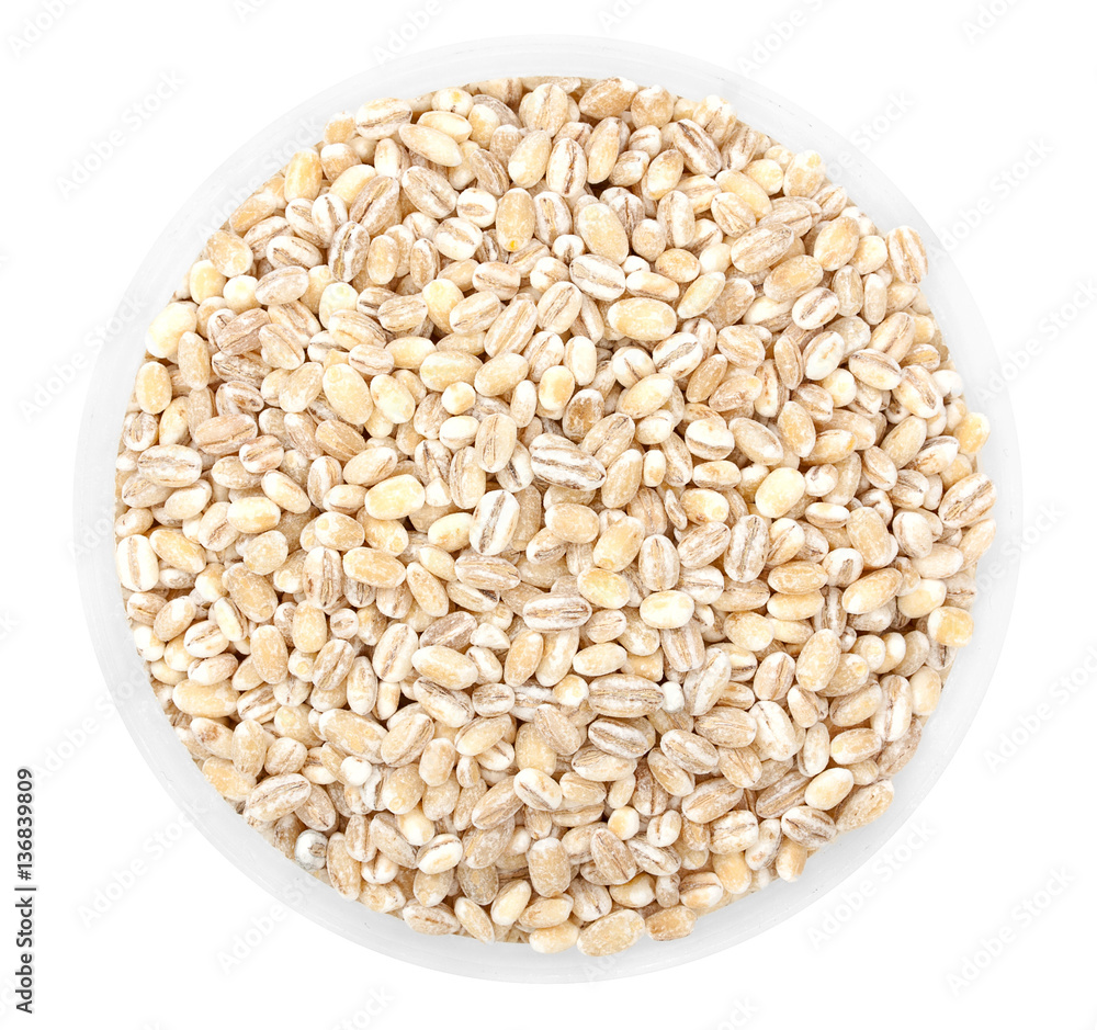 Heap of millet, bulrush groats in round plate isolated on white.