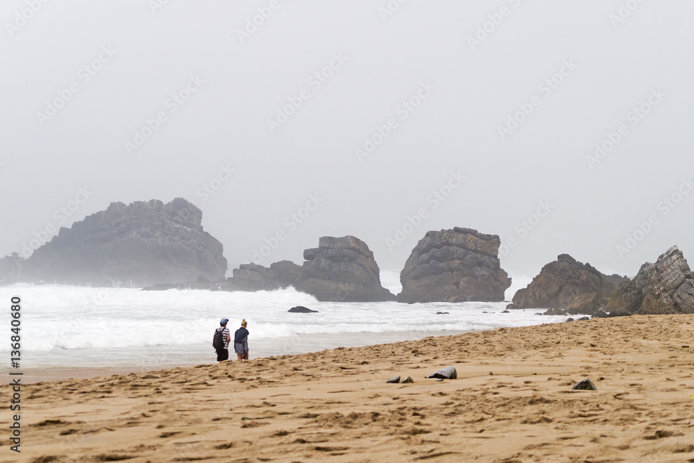 Young couple walk on foot along the shore of the ocean. Young couple walk on foot along the shore of the ocean.