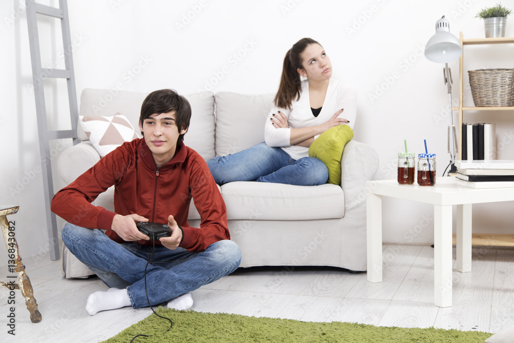 Obraz premium Girl is bored and angry while her boyfriend playing video game