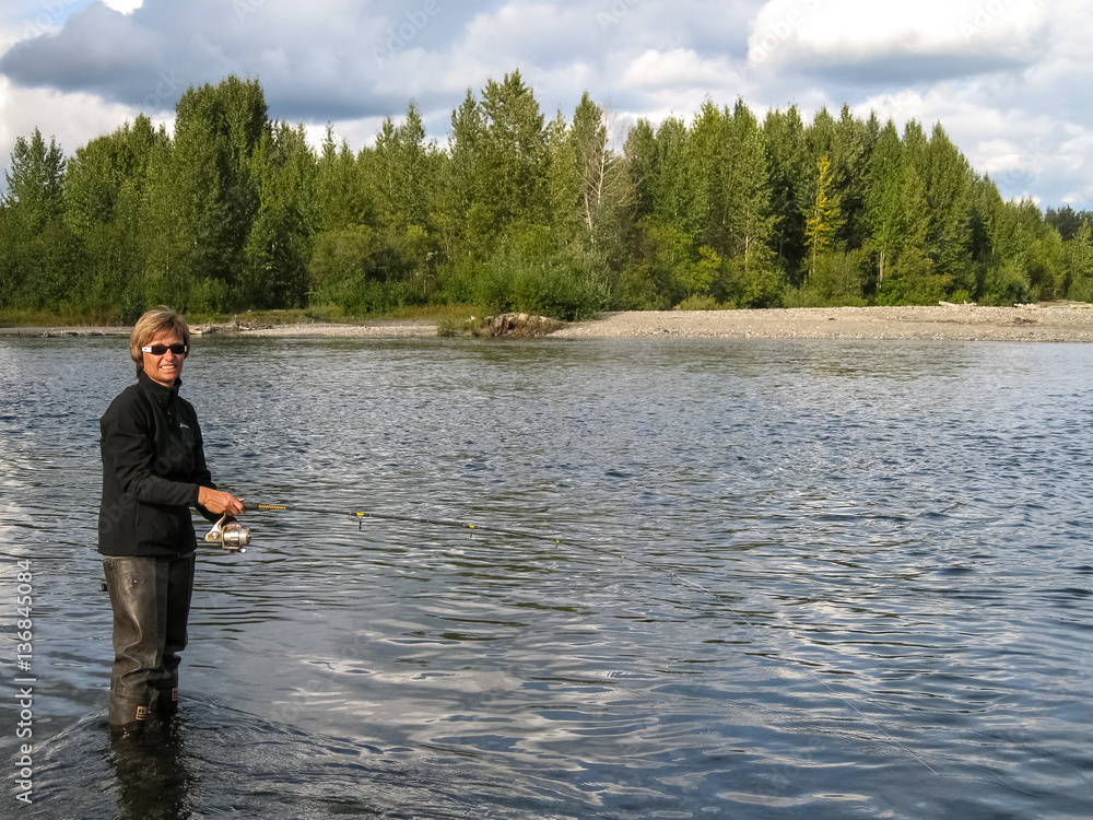 Woman fishing for salmon, Talkeetna River, Alaska