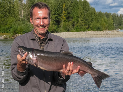 Angler with its catch, a Silver Salmon, Talkeetna River, Alaska