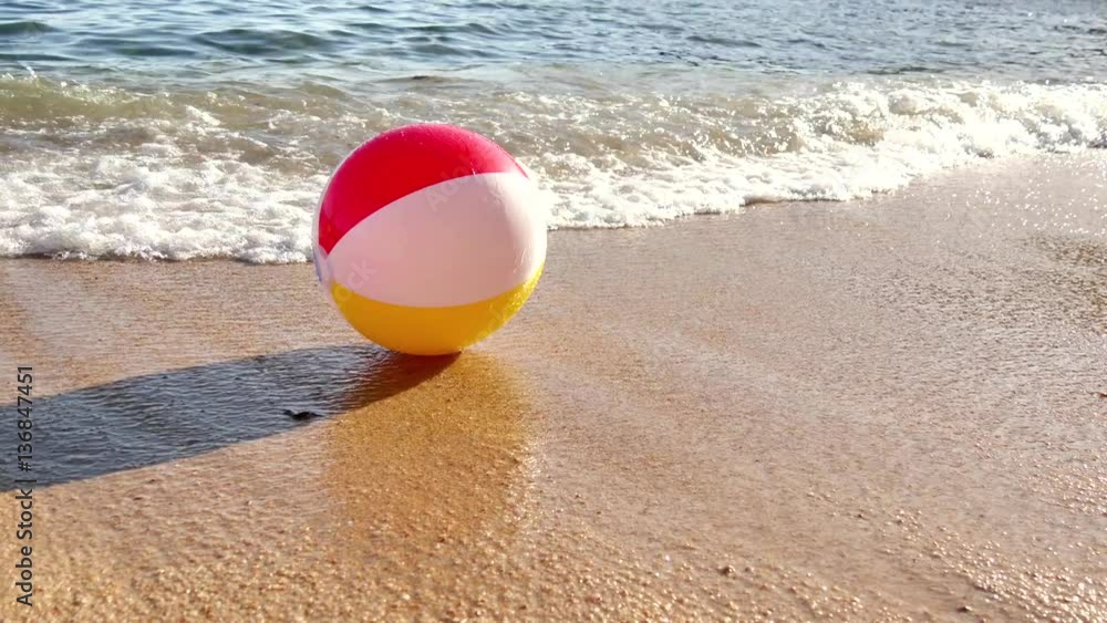 Beach Ball at the Mercy of the Waves. The sea dragging a beach ball and