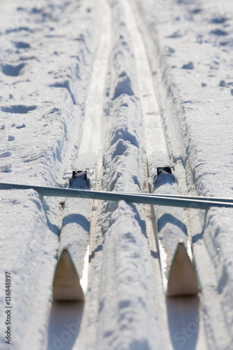 Healthy lifestyle wintersport. Cross-country skiing equipment on snow field. Crossed skis and ski poles on track