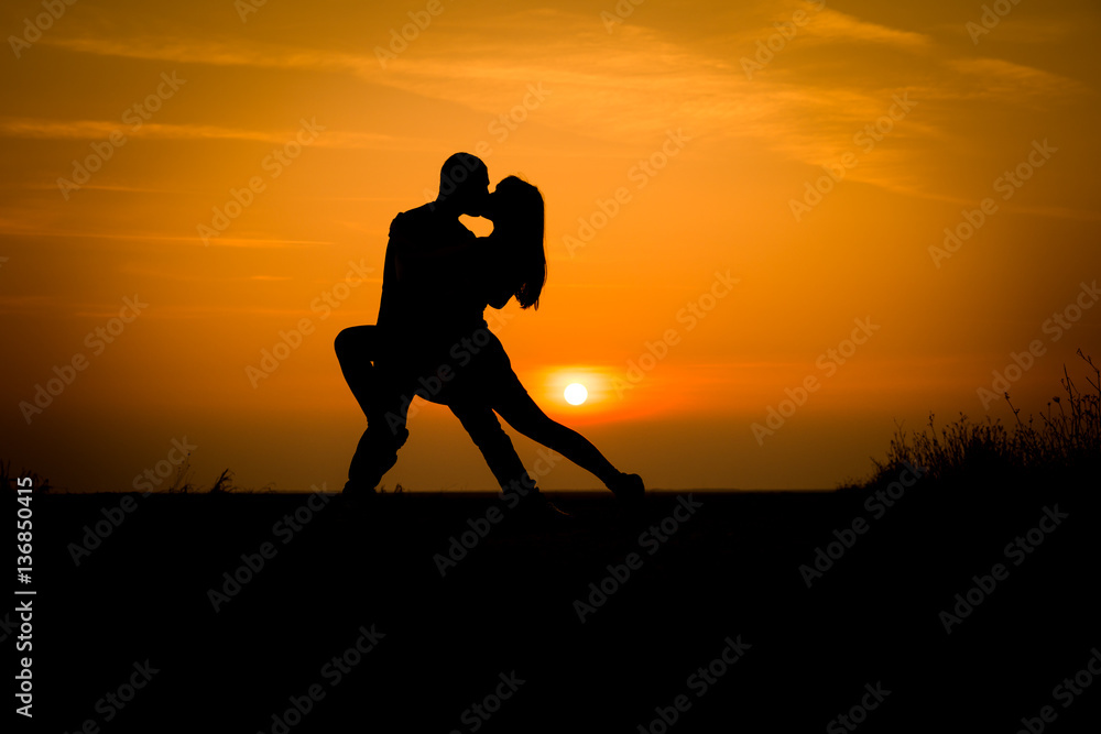 silhouette teenager lovers couple with sun between on sunset dusk sky background: black shadow hand drawn of people hug and kiss people:passion in love concept:decoration,design,valentines silhouette teenager lovers couple with sun between on sunset dusk sky background: black shadow hand drawn of people hug and kiss people:passion in love concept:decoration,design,valentines