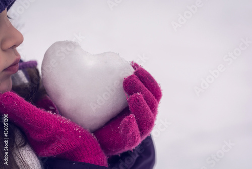 Girl lovingly gives icy heart. Valentine's day.