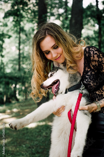 The girl with the siberian husky. Delightful girl plays with a Siberian Husky. Girl walking with a hunting dog - the West Siberian husky.