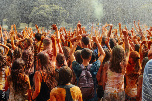 hands and happy people crowd partying under rain at holi fest, f