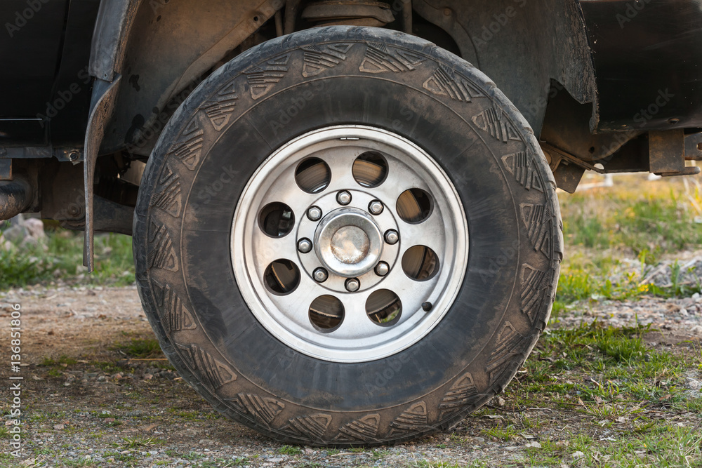 SUV car wheel on dirty rural road