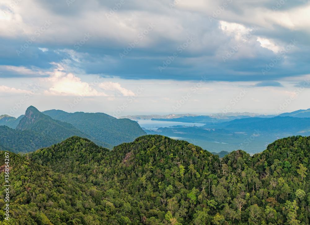 Panoramic view of the mountains covered with tropical forests and the sea on the horizon, Langkawi Island, Malaysia. Dramatic sky with clouds.
