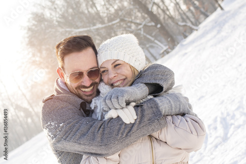 Smiling couple hugging and enjoying outdoors in winter