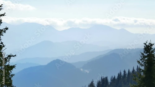 Mountain ridges over blue sky during sunrise with spruce forest in the foreground and layers of hills. Macedonian Pine (Pinus peuce) grow on slopes at Snezhanka peak, Pamporovo winter ski resort, Rhod photo